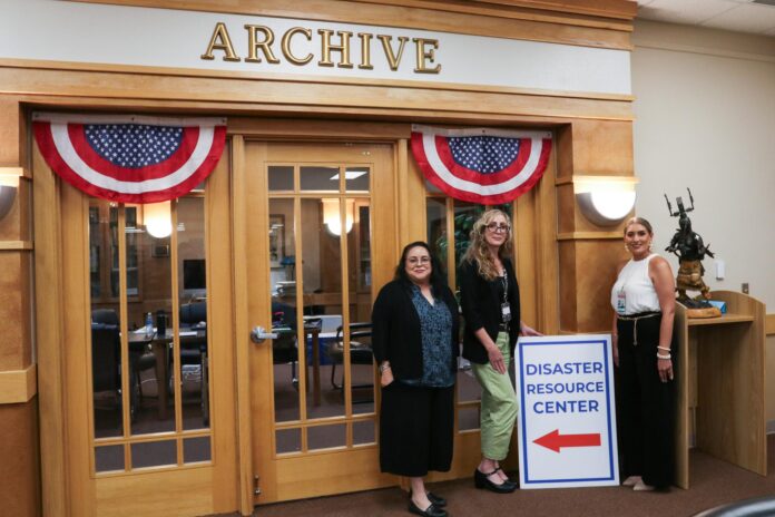 Bebee Manrique-McMillan (left), Alice Medina (center) and Yolanda Garwood (right) stand in front of the Home Recovery Program’s workshop room on Thursday, Aug. 27 at the Ruidoso Public Library.